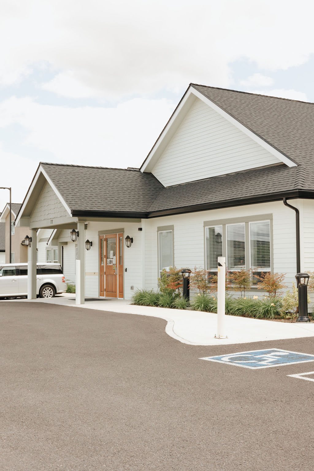 A suburban house with a parking area featuring an accessibility sign.