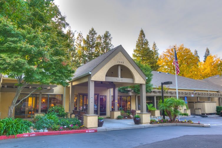 A welcoming building entrance surrounded by trees and greenery.