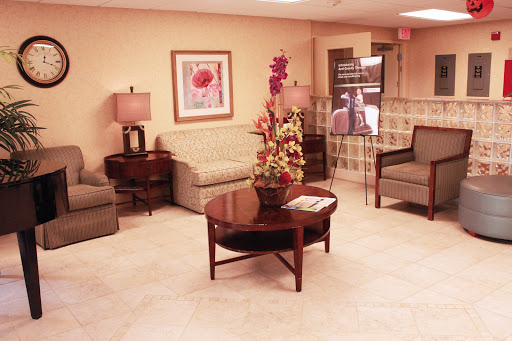 A cozy waiting area featuring comfortable sofas and a decorative coffee table with flowers.