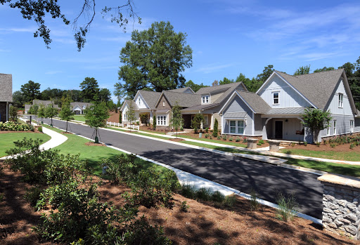 A peaceful suburban neighborhood showcasing well-maintained homes and a clear blue sky.