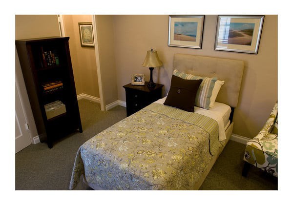 A cozy bedroom with a single bed, nightstand, and decorative artwork.