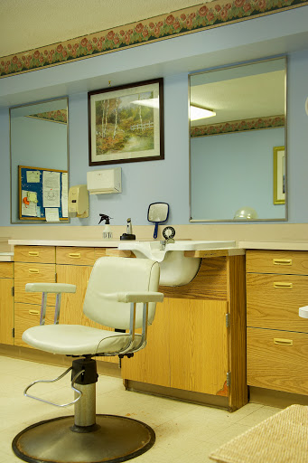 A view of a dental office featuring a comfortable dental chair, cabinets for equipment, and mirrors reflecting a calm environment.