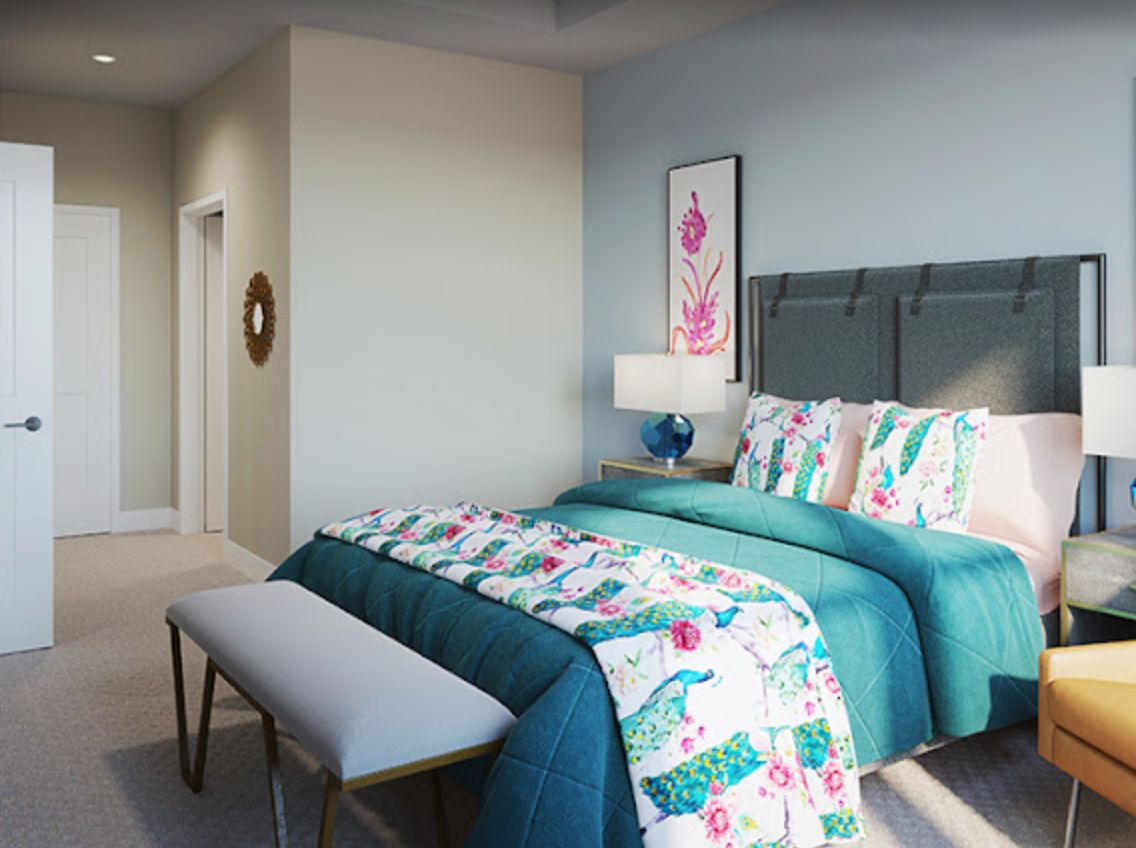 A stylishly decorated bedroom featuring colorful bedding and modern furniture.