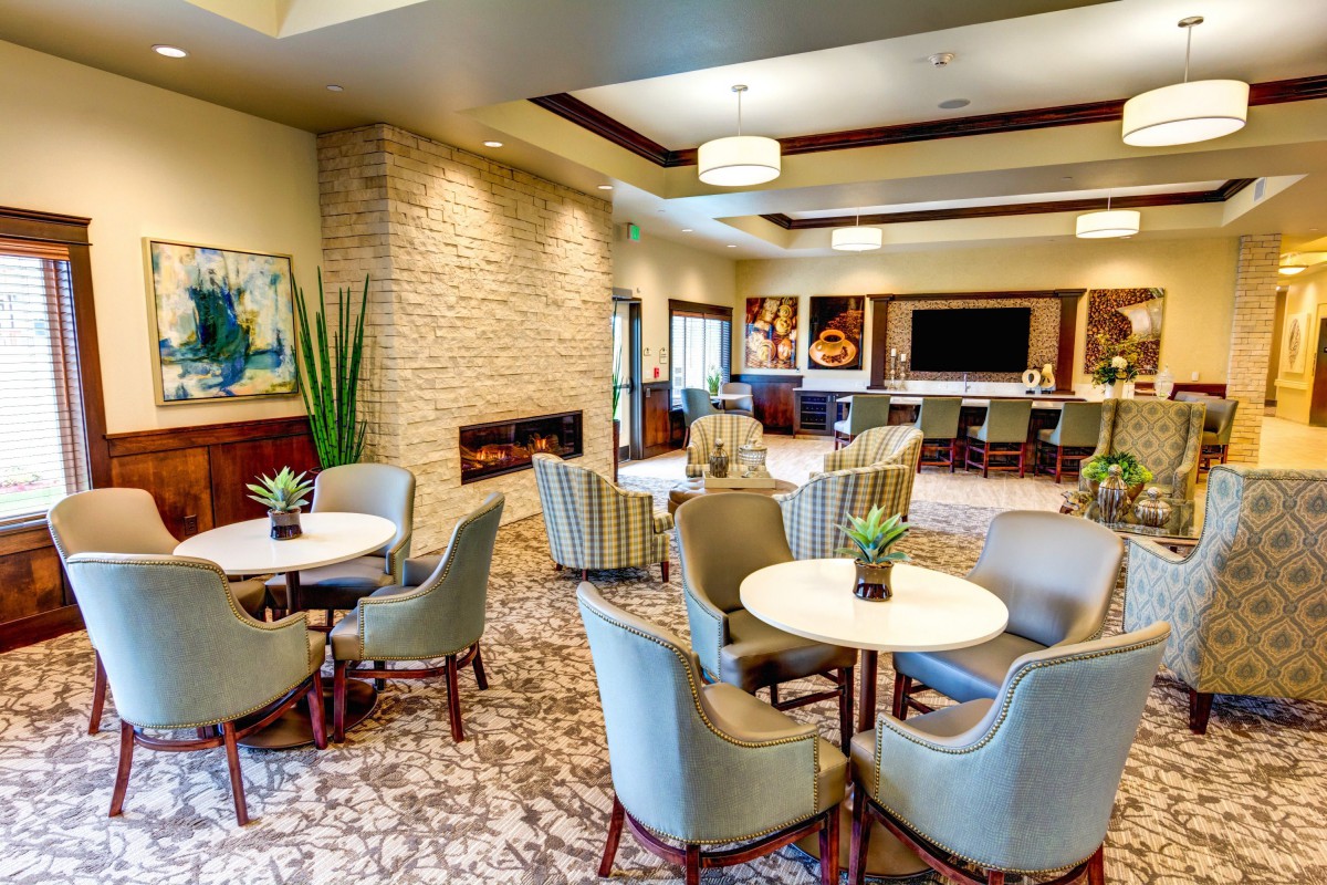 A modern lounge with comfortable seating, a fireplace, and decorative artworks.