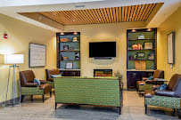 A modern lounge area with comfortable seating, a television, and decorative shelves.