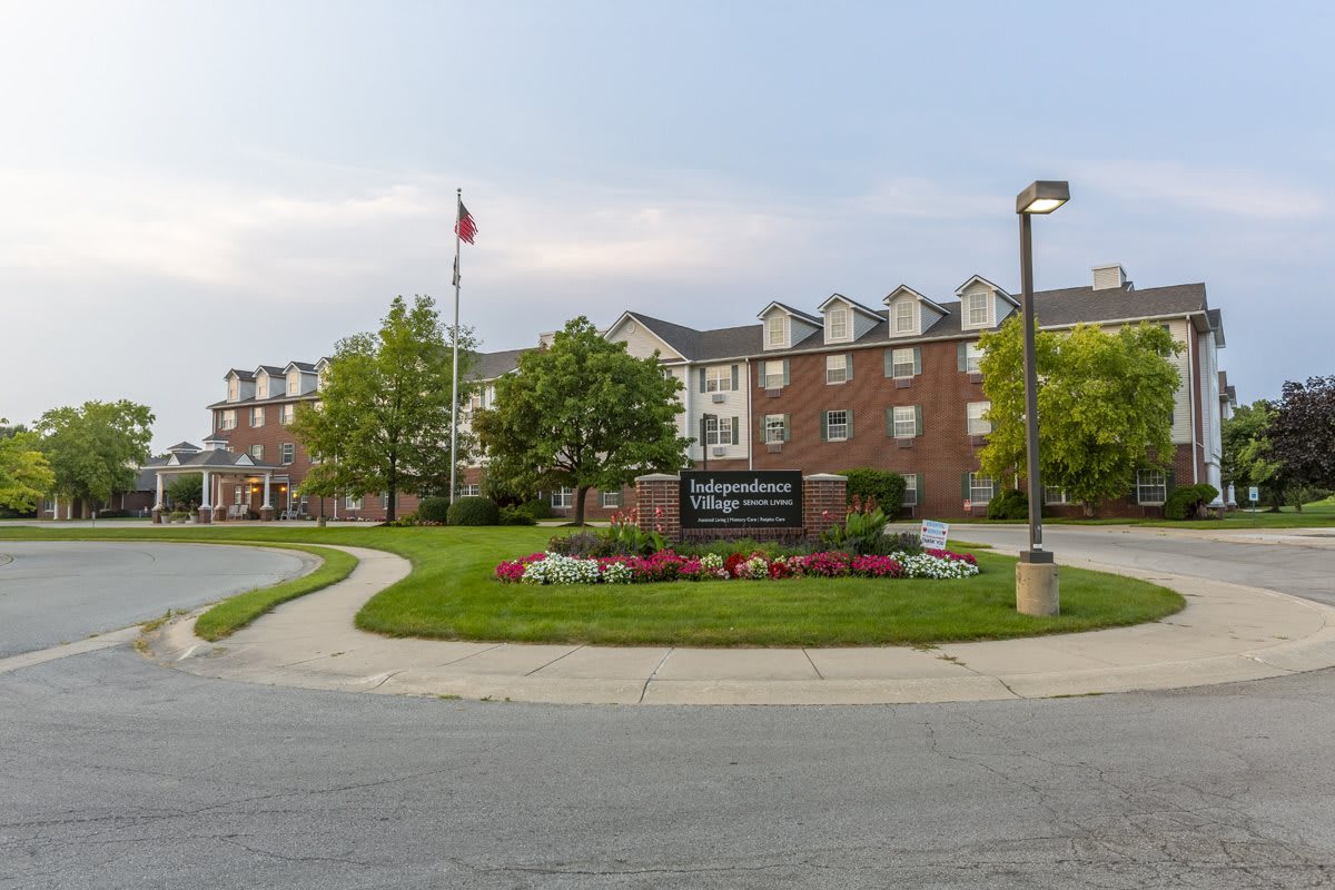Exterior view of a hotel with a landscaped entrance and signage.