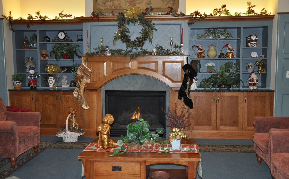 A cozy Christmas-themed living room with a decorated fireplace and stockings hanging from the mantel.