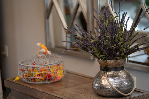 A beautifully arranged interior scene featuring a vase of lavender and a colorful bowl of candy on a wooden table.