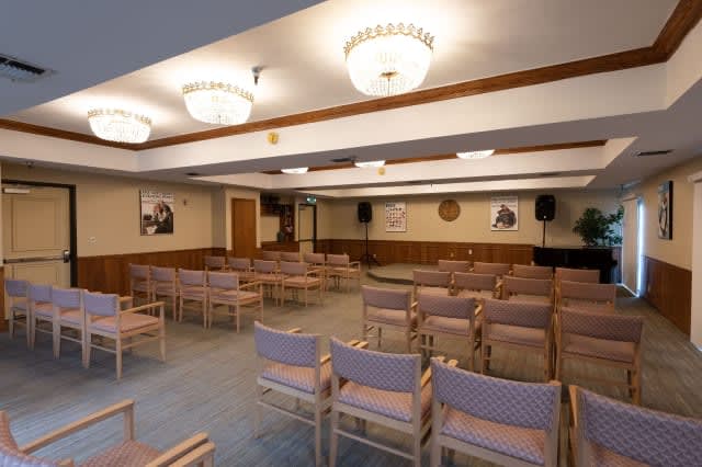 An empty conference room with rows of chairs set up for a meeting or presentation.