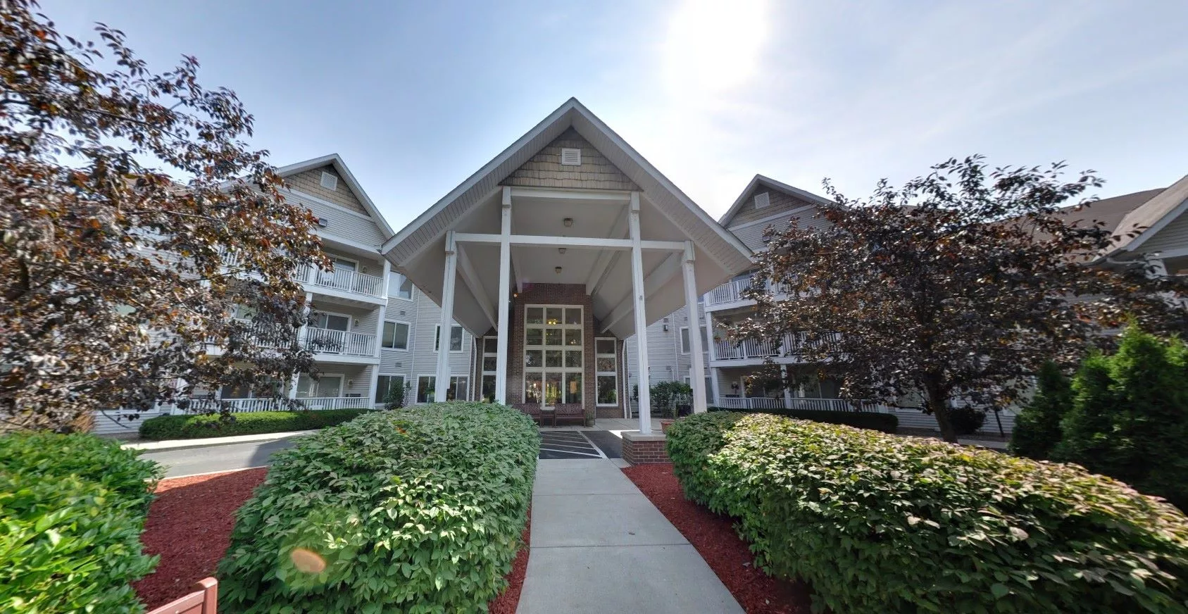 A residential building with a grand entrance and well-maintained landscaping.