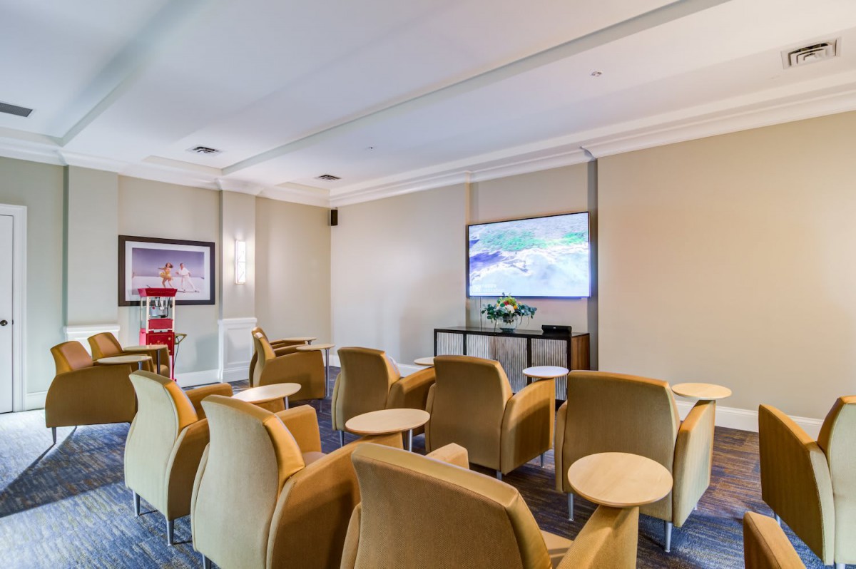 A cozy lounge area with comfortable chairs facing a large television.