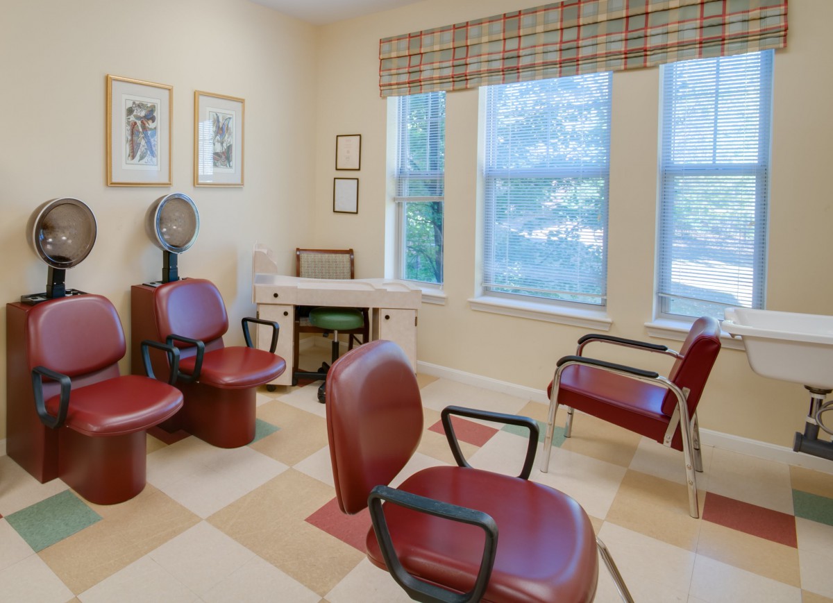 A cozy hair salon waiting area with comfortable seating and natural light.
