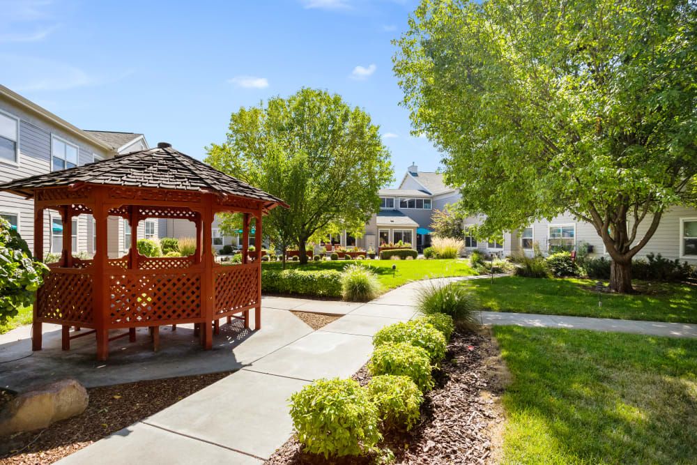 A serene garden with a gazebo and well-maintained pathways on a sunny day.