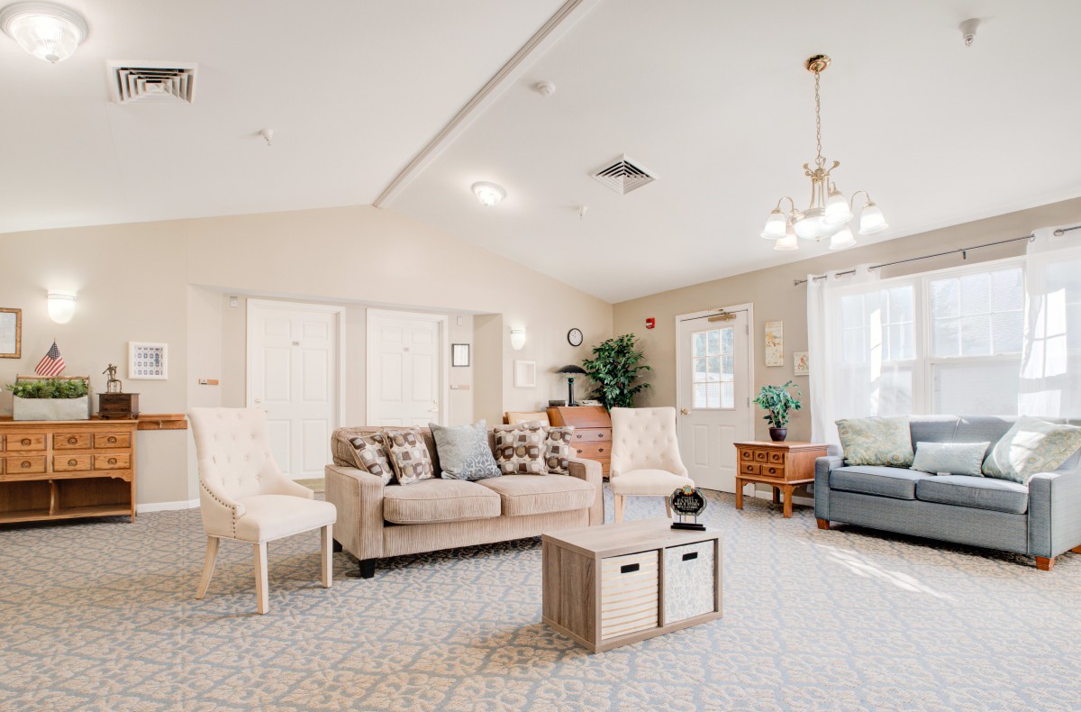 A spacious and well-lit living room featuring comfortable seating, modern decor, and natural lighting.