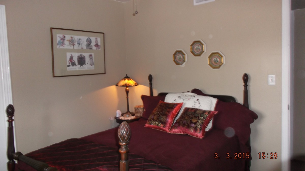 Cozy bedroom with decorative pillows and a vintage lamp.