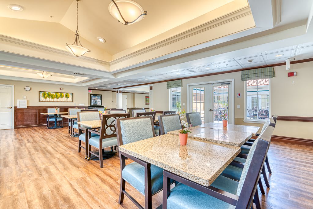 A well-lit dining room featuring tables and chairs arranged neatly.