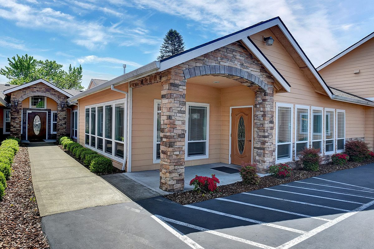 A modern office building with a stone facade and well-maintained landscaping.