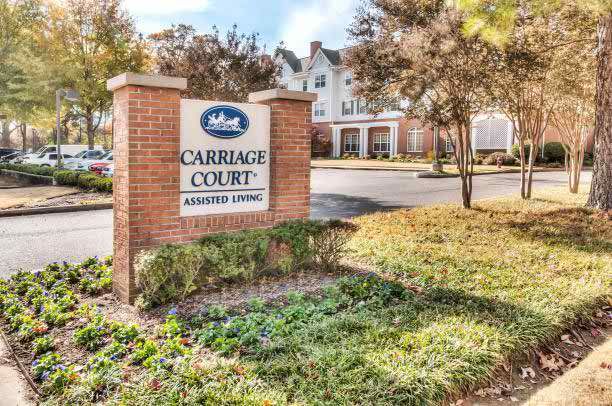 Sign for Carriage Court Assisted Living with building in the background.