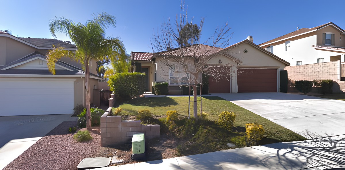 A suburban house with a neatly landscaped front lawn and a double garage.