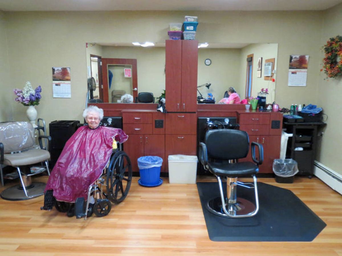 A person in a wheelchair at a hair salon, preparing for a haircut.