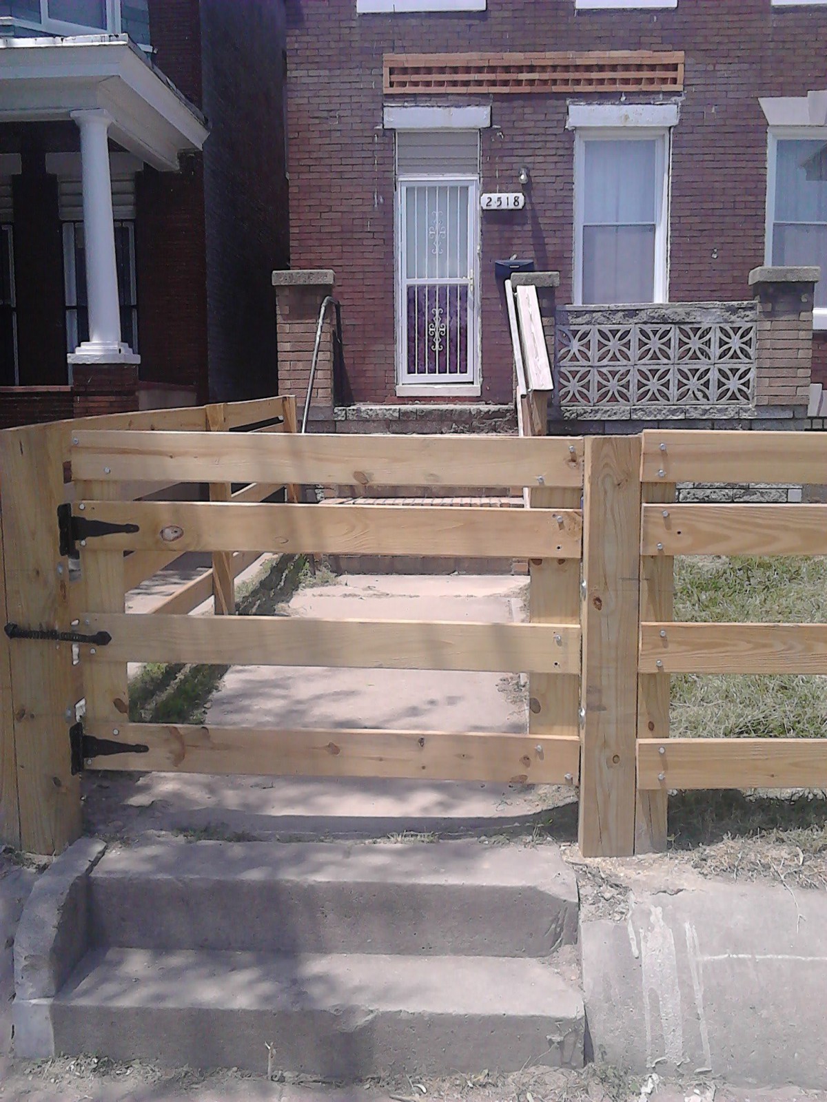 A newly installed wooden gate in front of a house.