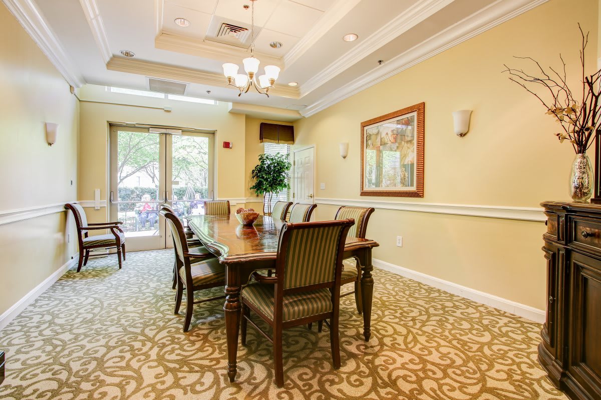 A well-appointed dining room featuring a long table with chairs, elegant lighting, and tasteful decor.