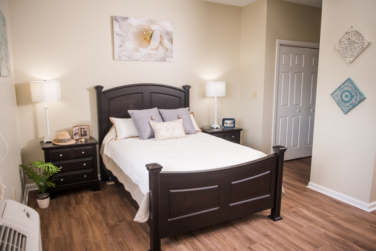 Cozy bedroom with a dark wood bed frame, elegant decor, and soft lighting.