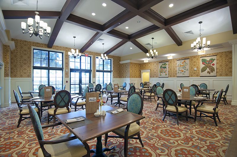 A spacious dining area with elegant furnishings and large windows.