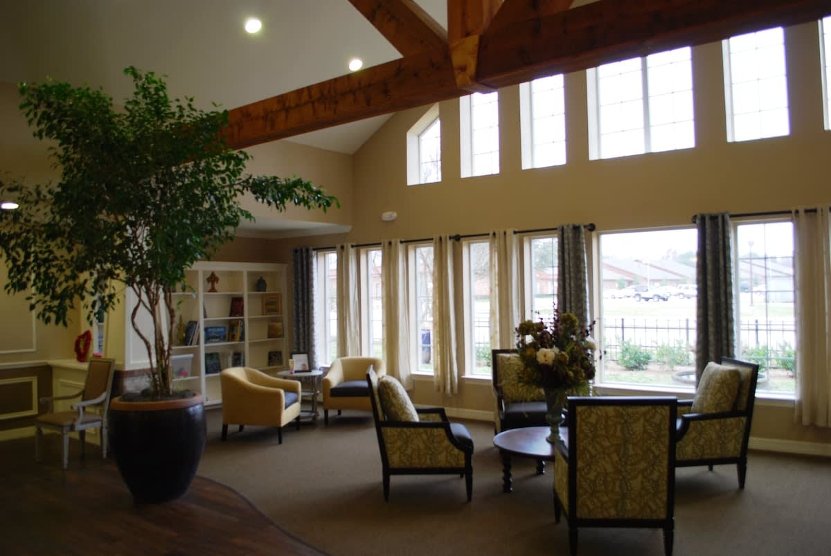 A spacious lounge area with large windows, comfortable seating, and natural lighting.