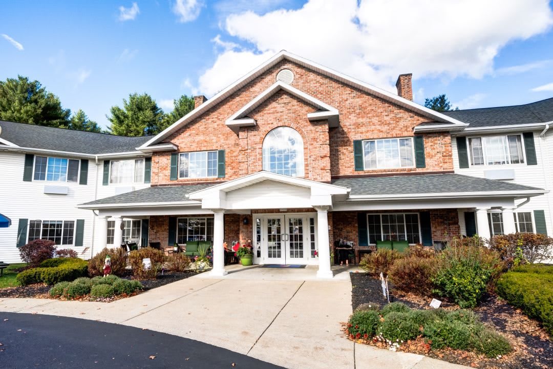 A two-story brick building with a landscaped entrance and driveway.