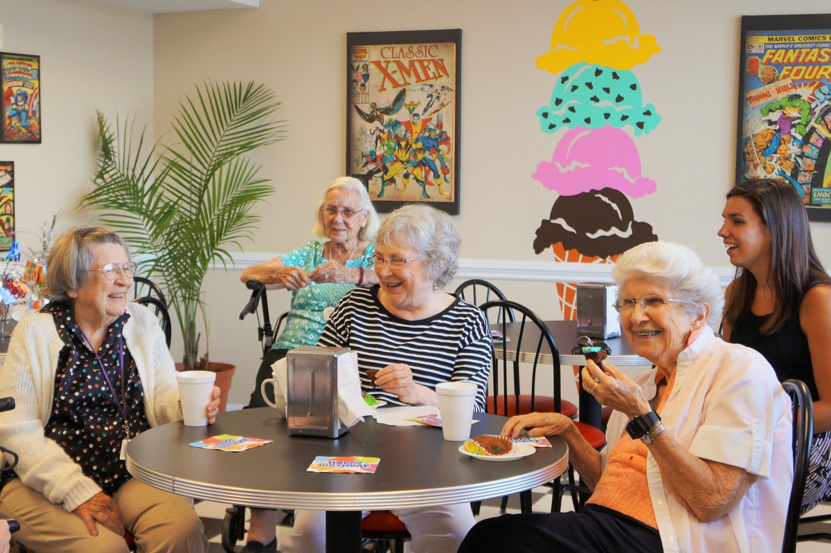 A group of seniors enjoying drinks and conversation at a cafe.