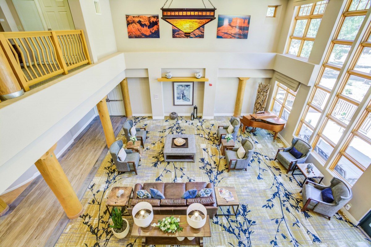 A bright and spacious lobby with comfortable seating and decorative artwork on the walls.
