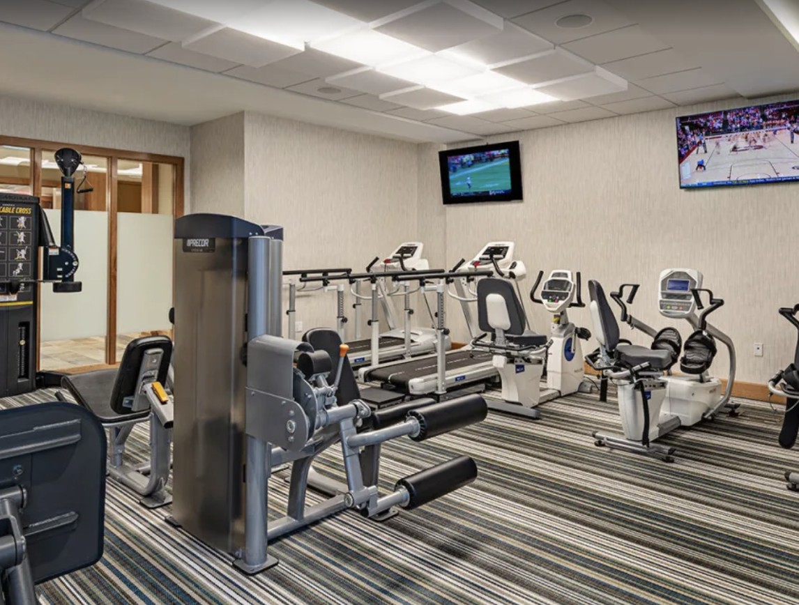 A well-equipped gym with various exercise machines, including stationary bikes and treadmills.