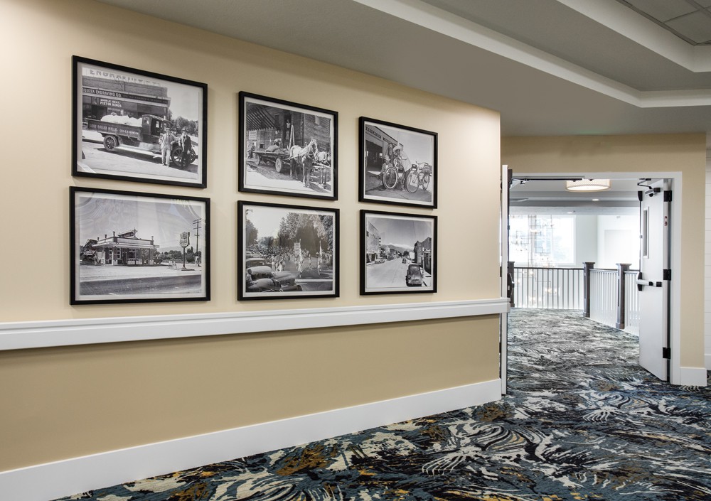 A hotel hallway featuring framed black and white photographs on the wall.