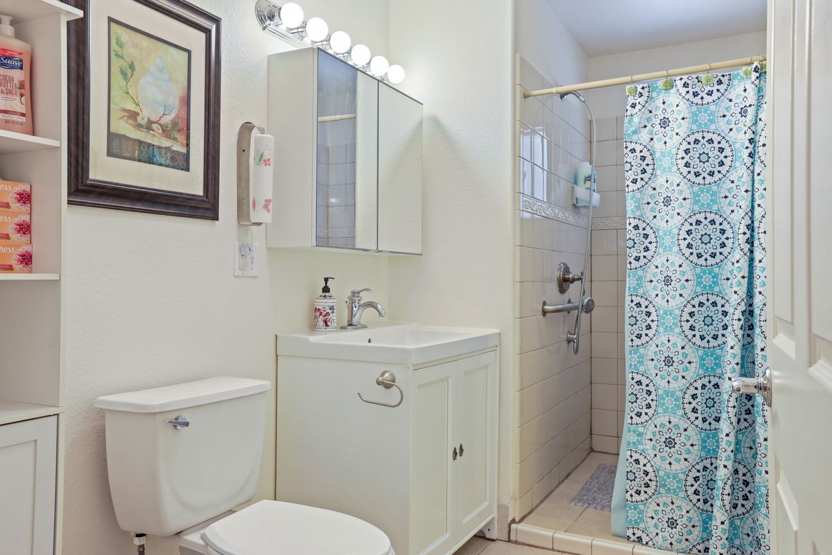 A clean and modern bathroom with a shower, vanity, and toilet.