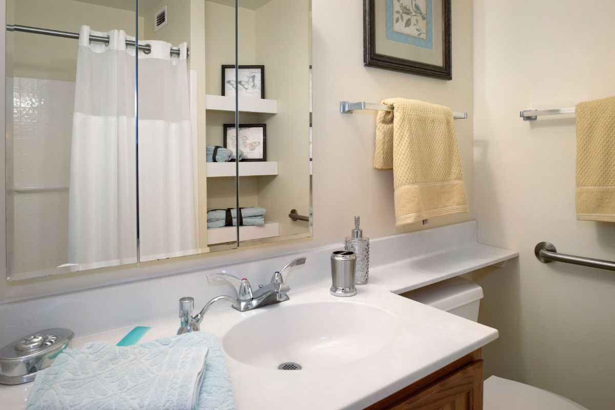 A well-organized bathroom with a clean sink and neatly hung towels.