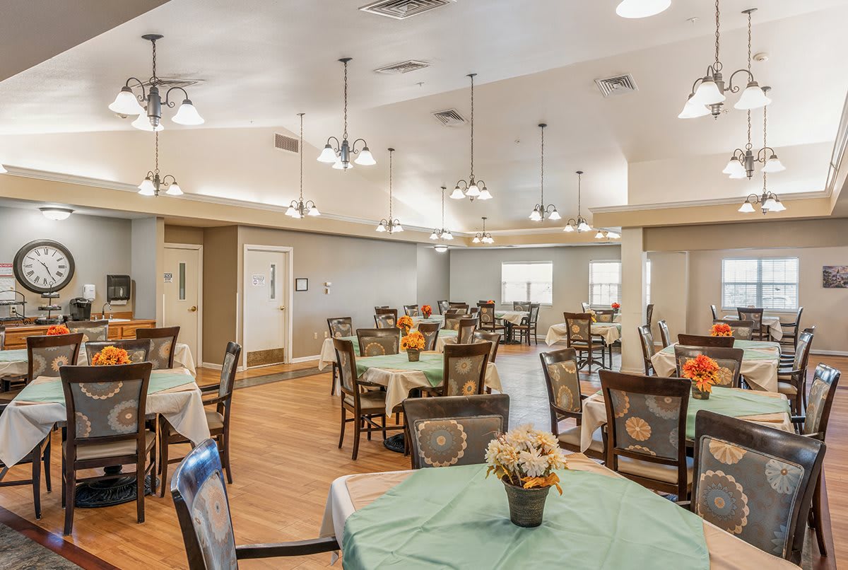A spacious dining area with multiple tables and decorative lighting.