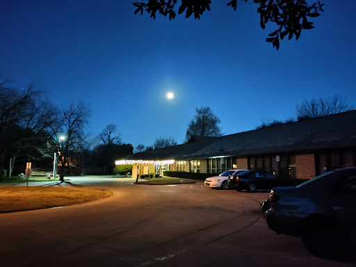 A serene night scene featuring a bright moon over a quiet parking area.