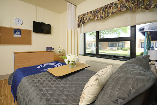 A cozy and modern bedroom featuring a comfortable bed, a small table, and a television.