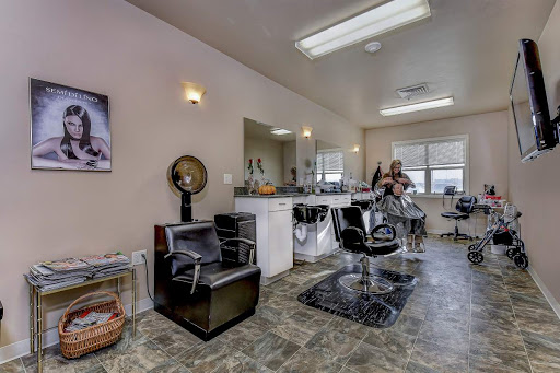 A cozy and well-lit salon/barber shop featuring styling chairs and mirrors.