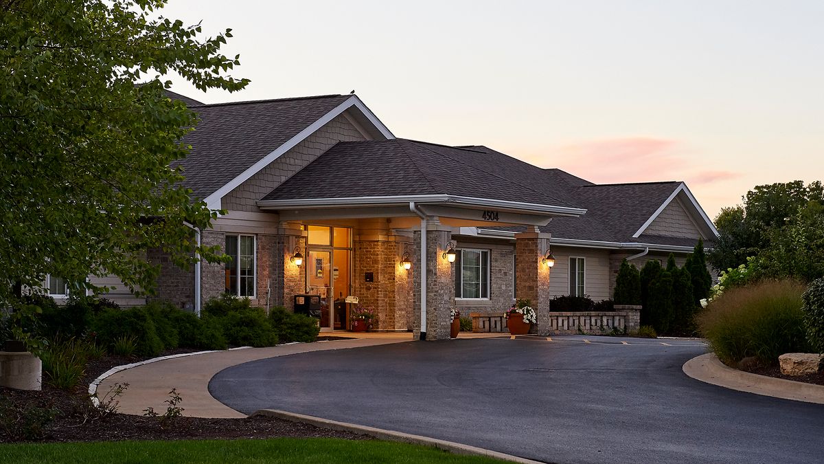 A cozy residential building with a warmly lit entrance at dusk.