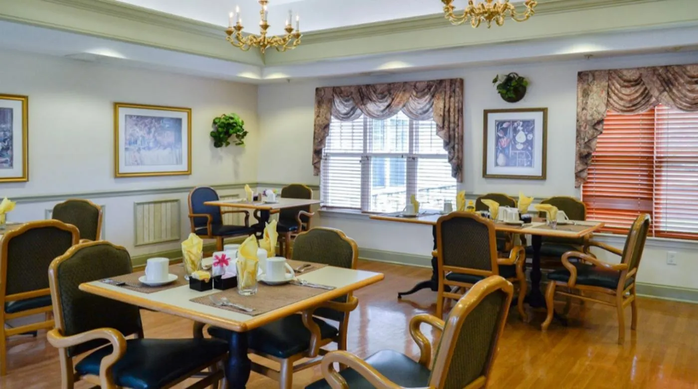 A well-decorated dining room featuring elegant chandeliers and neatly arranged tables and chairs.