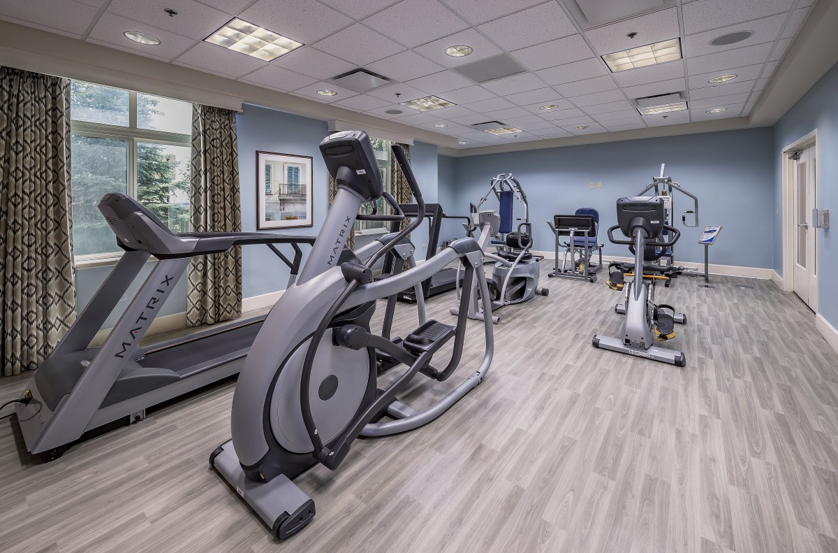 A modern gym equipped with various exercise machines, including treadmills and ellipticals.