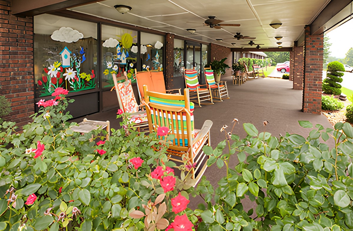 A colorful porch adorned with rocking chairs and blooming flowers.
