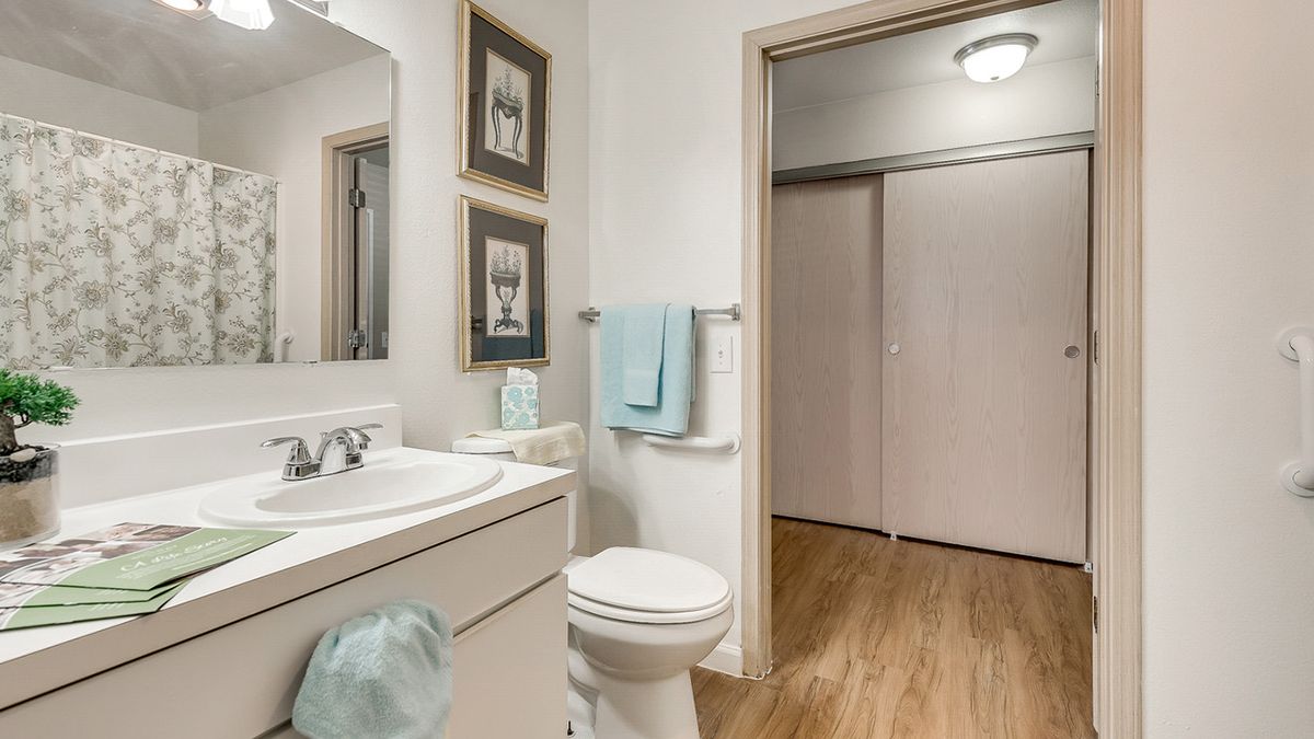 A clean and modern bathroom with a sink, toilet, and decorative artwork on the walls.