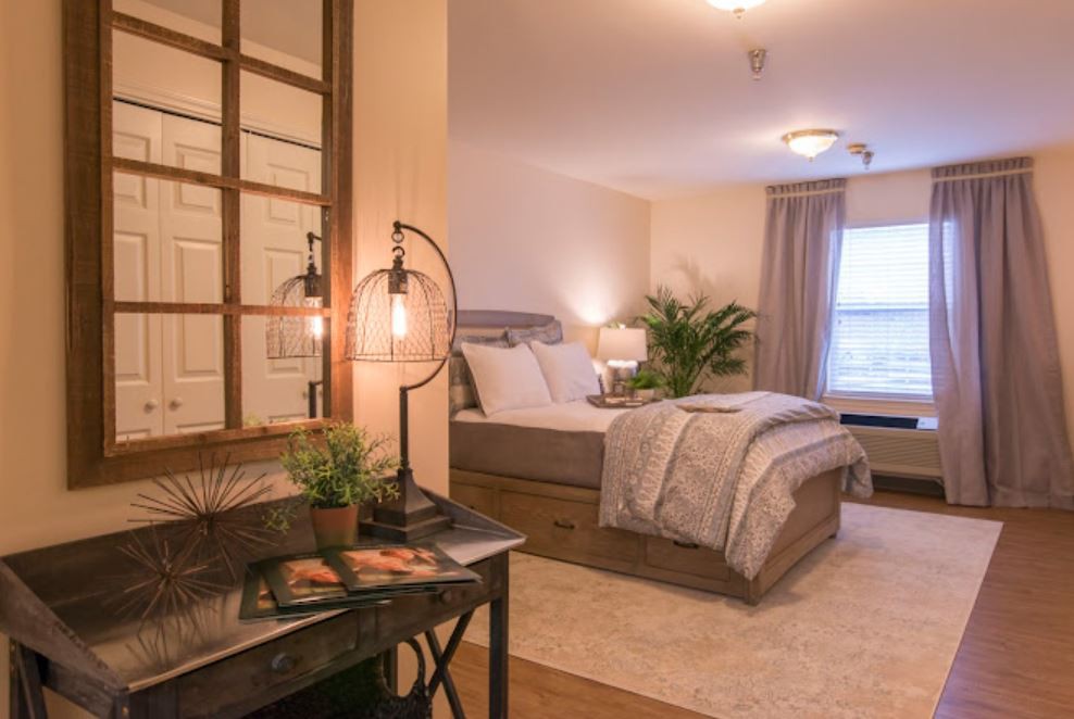 A cozy and well-decorated bedroom featuring a comfortable bed, stylish lamps, and lush plants.