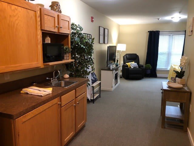 A cozy apartment interior featuring a kitchenette, comfortable seating area, and a mix of decor elements.