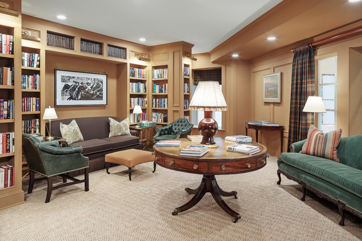 A cozy living room with built-in bookshelves and a central round table, creating a perfect reading nook.