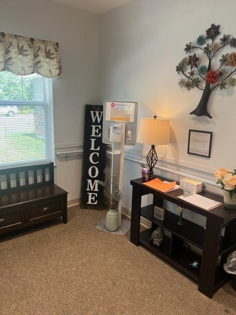 A cozy entryway with a 'Welcome' sign, a bench, and decorative elements.