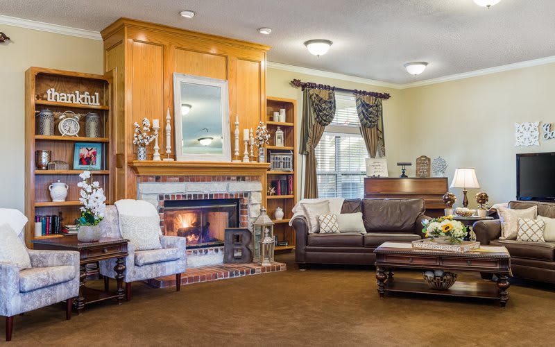 A cozy living room with a warm fireplace, comfortable seating, and elegant decor.